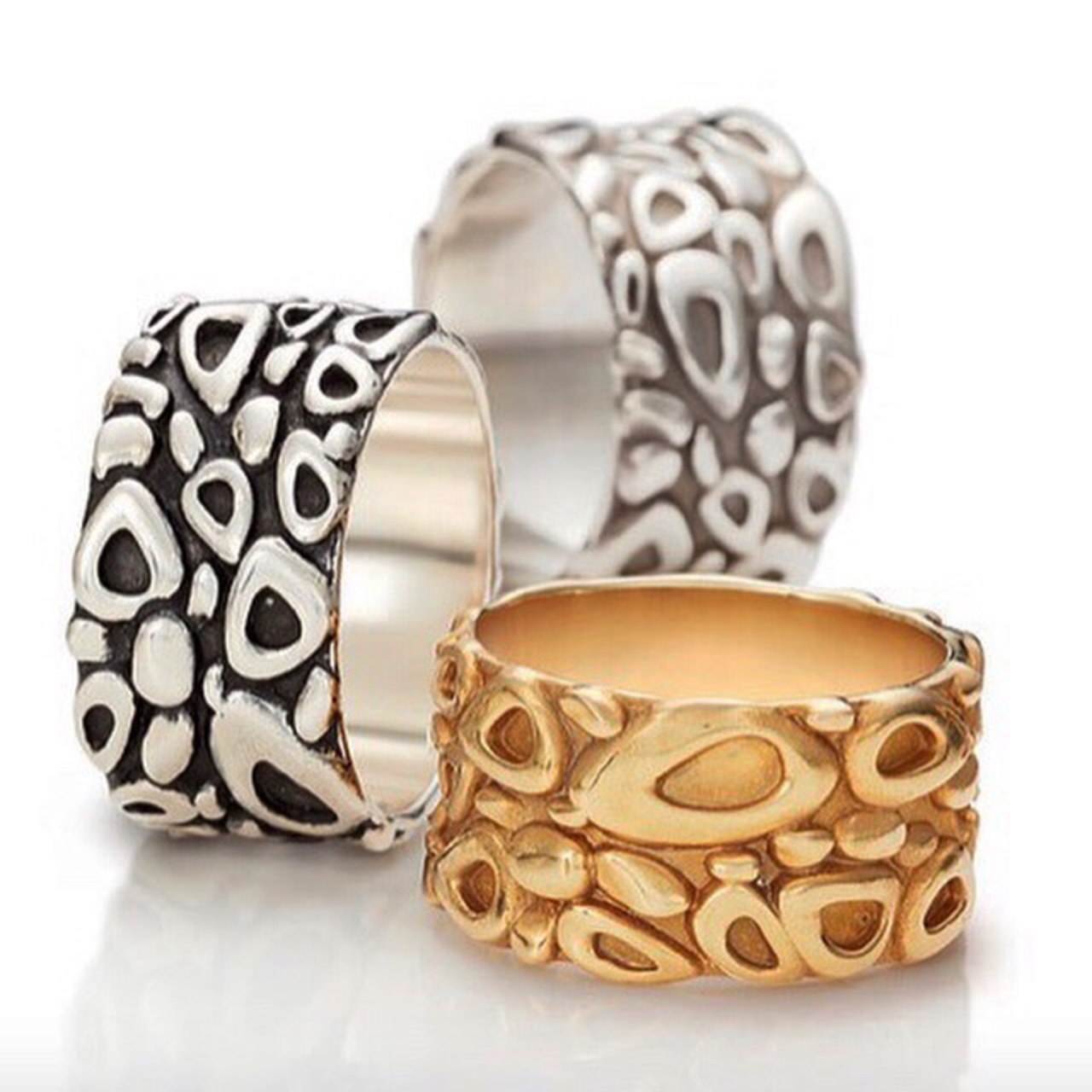 Three wide patterned rings in silver, oxidised silver and gold